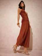 Woman wearing a rust-colored dress against a plain background