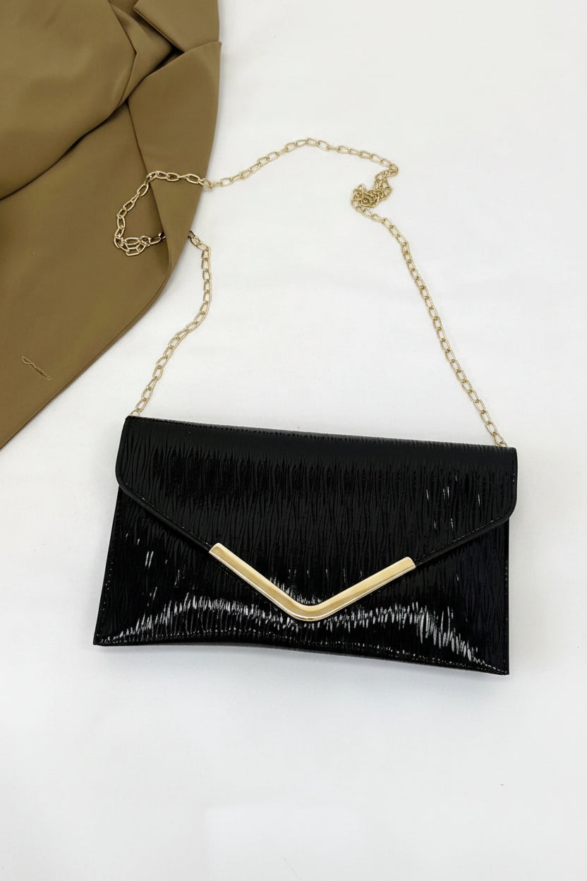 Black clutch with gold chain on a white background