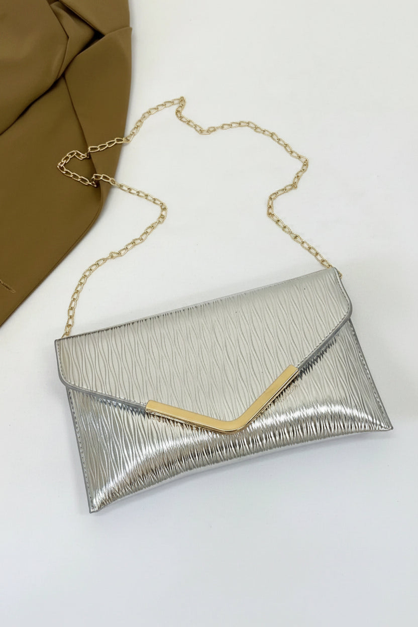 Silver clutch bag with gold chain on a white background