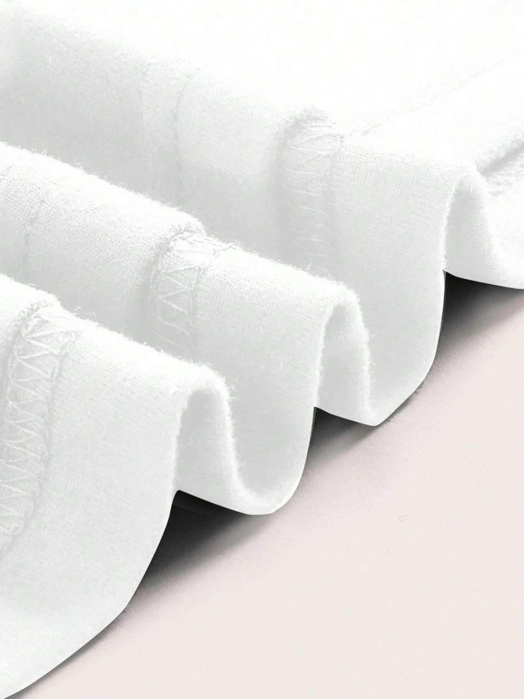 White ruffled fabric on a light gray background