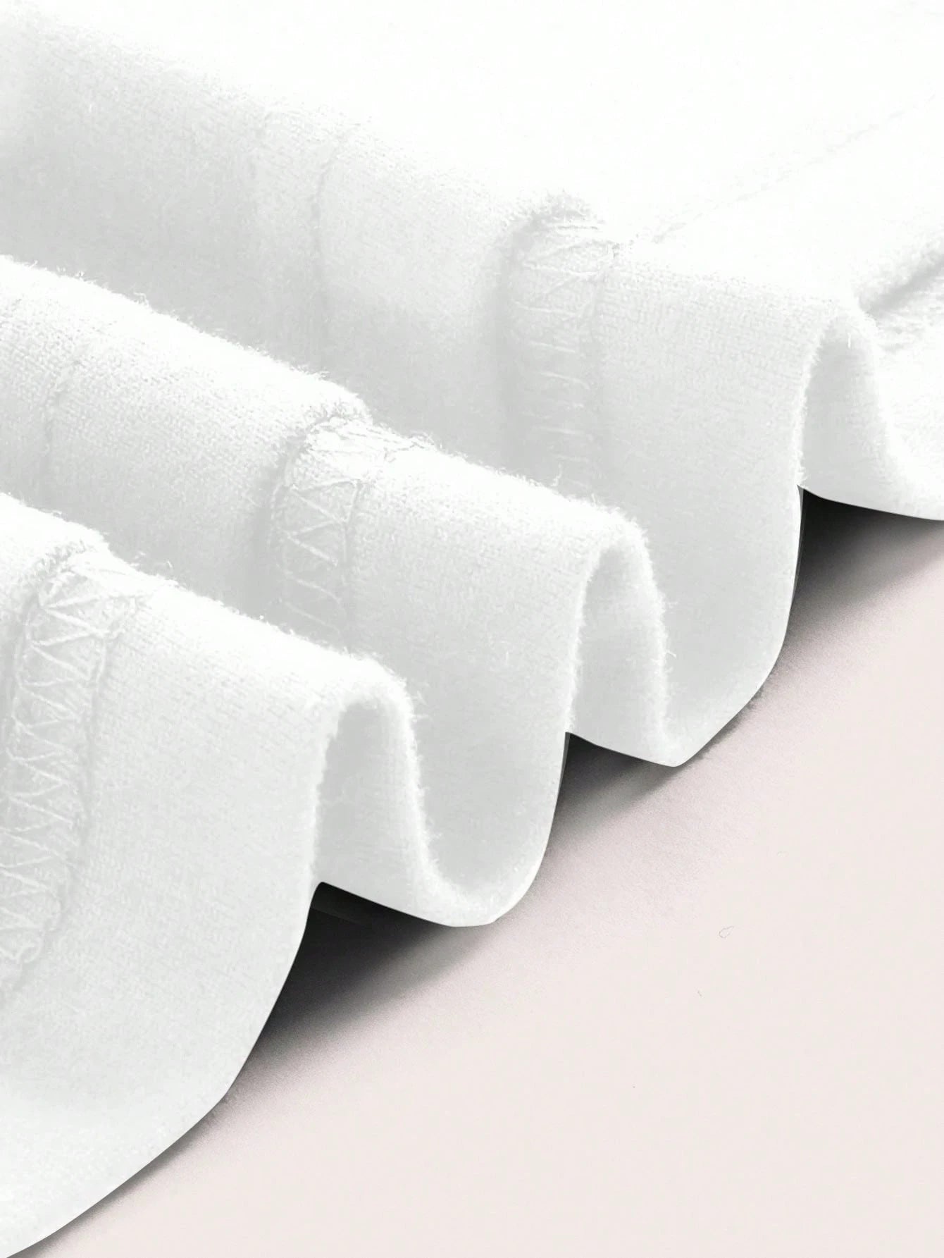 White ruffled fabric on a light gray background