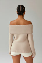 Beige off-shoulder sweater worn by a person on a plain background