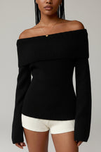 Black off-shoulder sweater worn by a model on a gray background