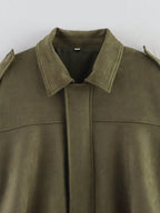 Close-up of a green suede jacket with a plain background