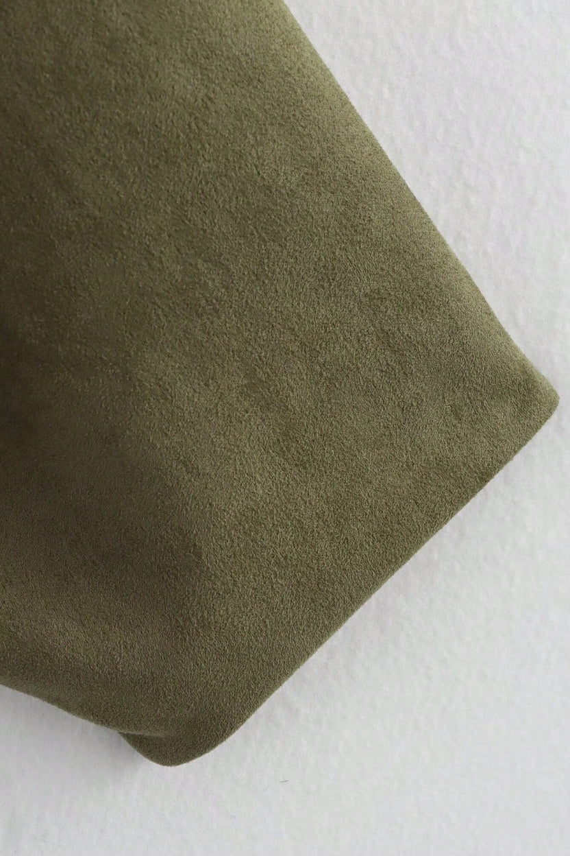 Close-up of a green fabric texture on a white background