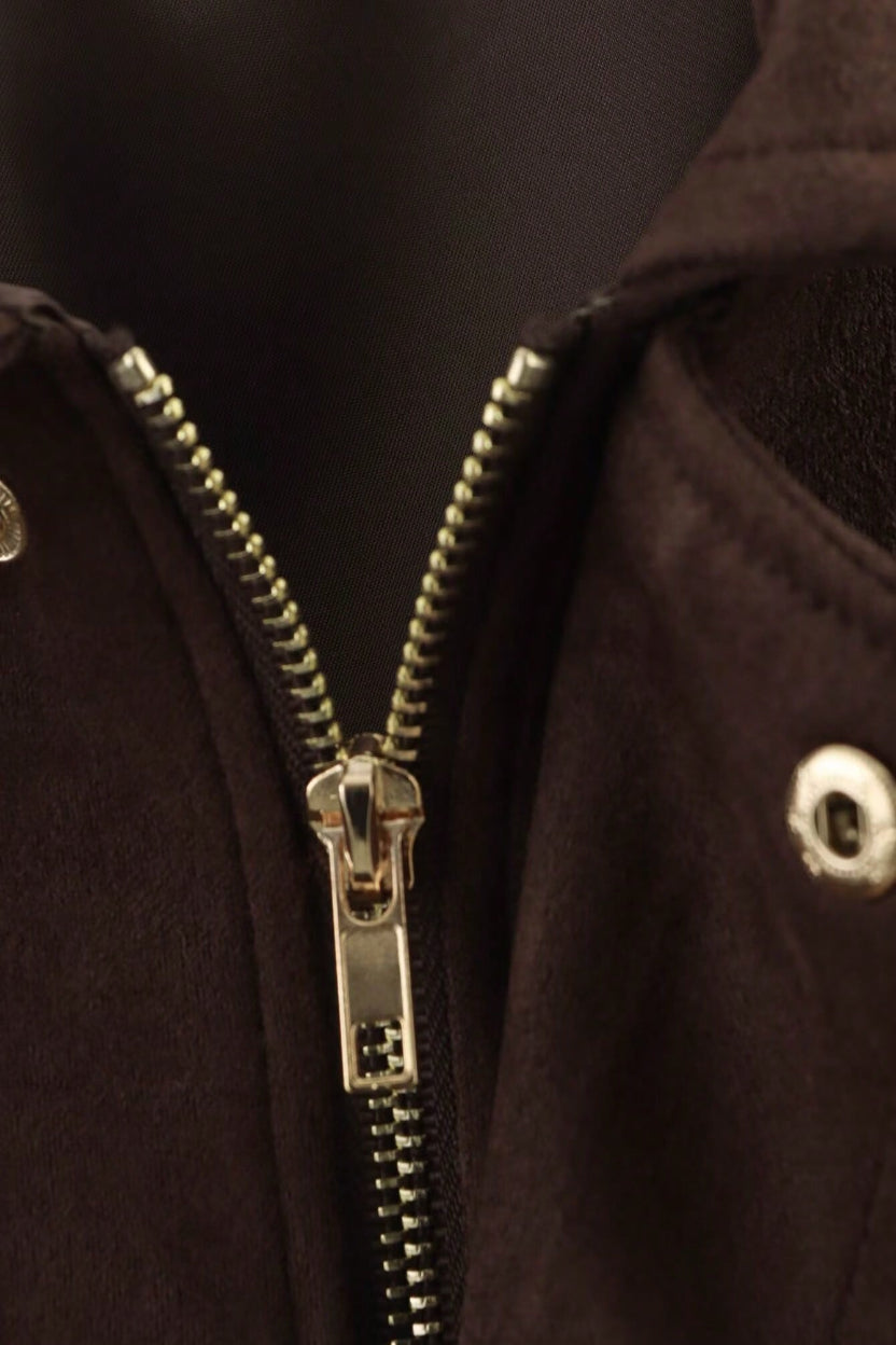 Close-up of a gold zipper on a dark brown jacket
