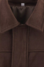 Close-up of a brown coat with a collar and button detail.