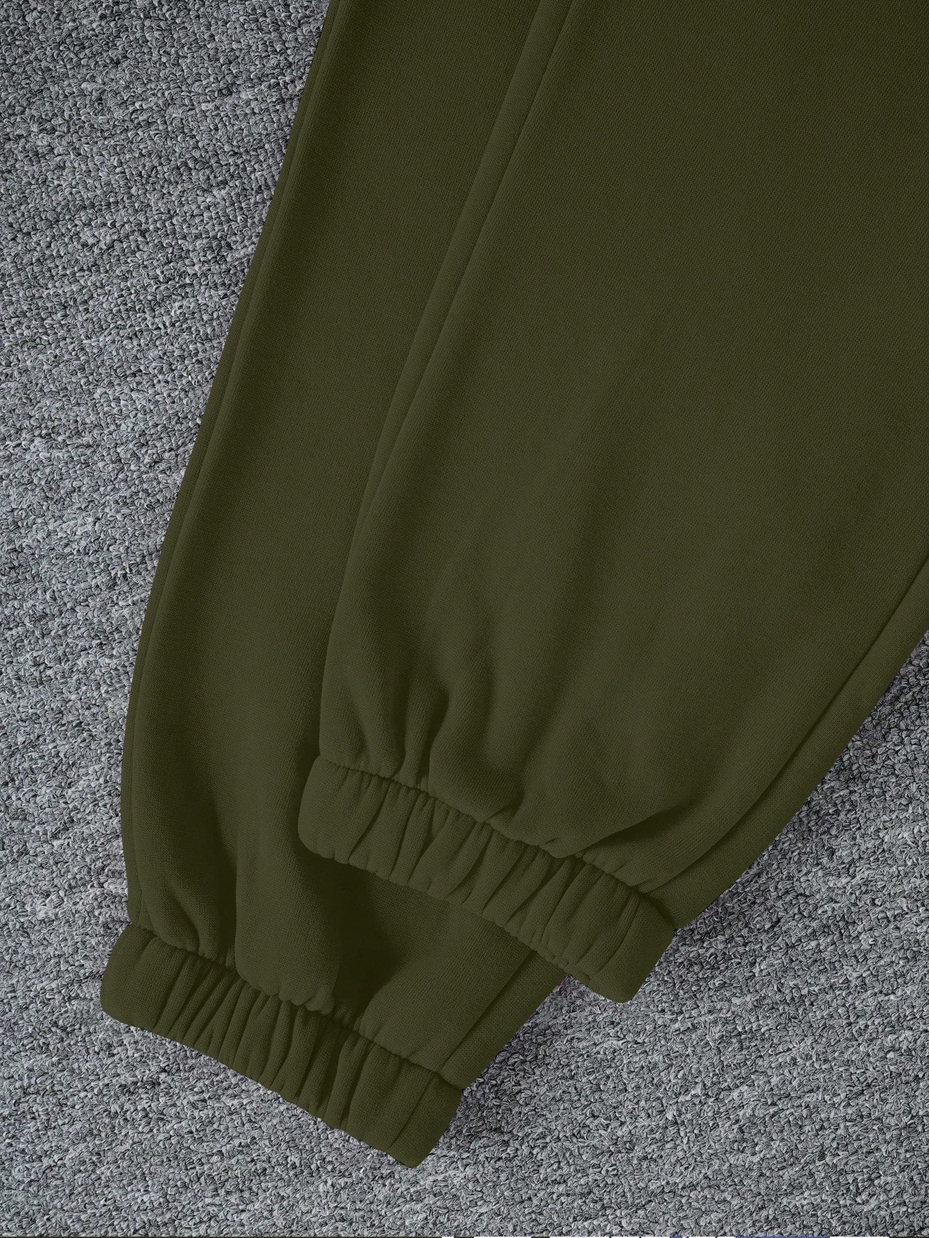 Green pants on a textured gray surface