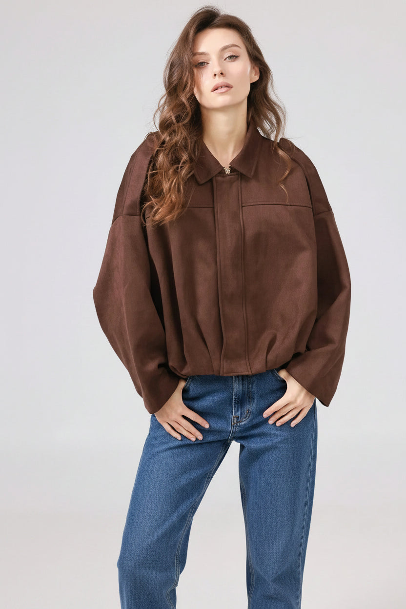 Woman wearing a brown jacket on a plain background