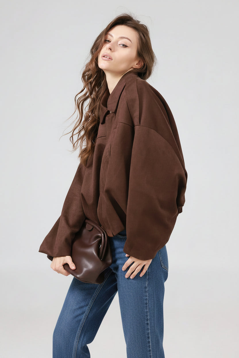 Woman wearing a brown oversized jacket on a plain background