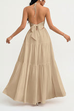Woman wearing a beige halter neck dress with a white background