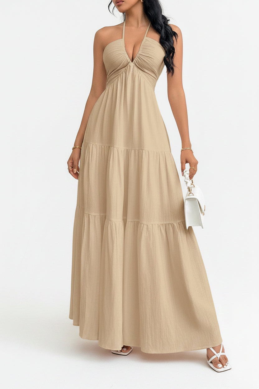 Woman wearing a beige halter neck dress with a white background