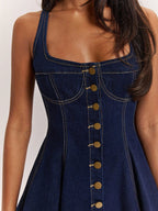 Denim dress with gold buttons on a plain background