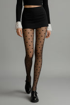Person wearing black heart-patterned tights.