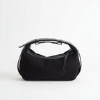 Black handbag with a reflective silver top on a white background
