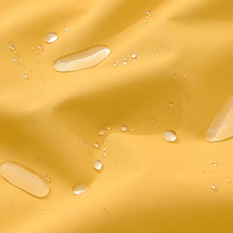 Close-up of water droplets on a yellow fabric surface