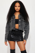 Woman wearing a black denim jacket and black leather skirt on a white background