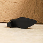 Black shoe sole on a wooden floor with a wooden wall background