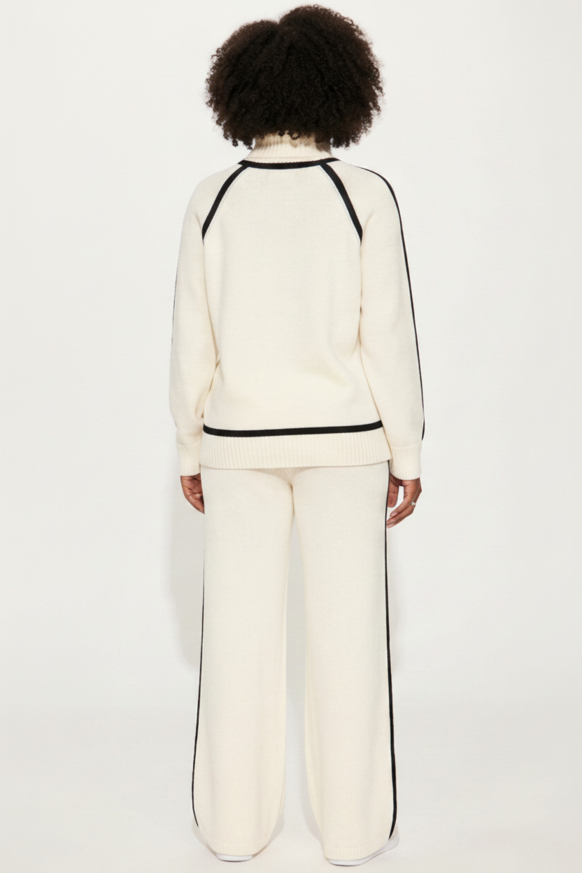 Person wearing a white outfit with black trim on a white background