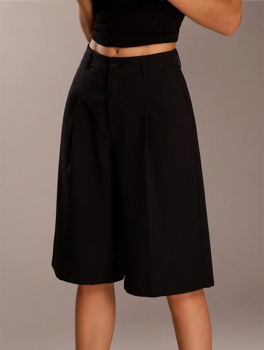 Black skirt worn by a person on a plain background