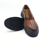Brown leather shoe with black sole on a white background