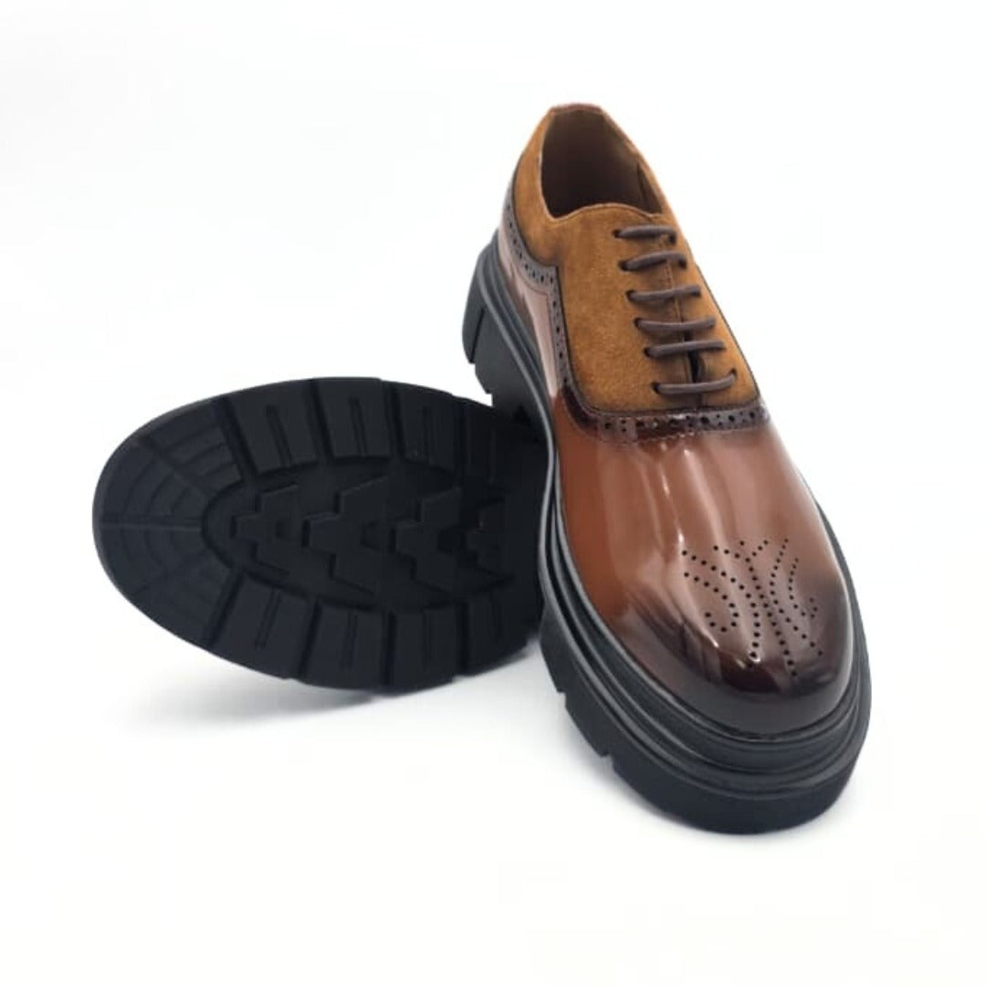 Brown leather shoe with black sole on a white background