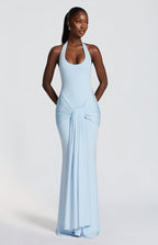 Woman wearing a light blue halter neck gown on a white background