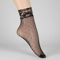 Black fishnet sock with lace top on a white background