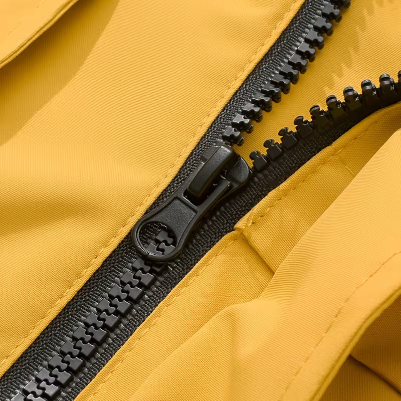 Close-up of a black zipper on a yellow fabric background
