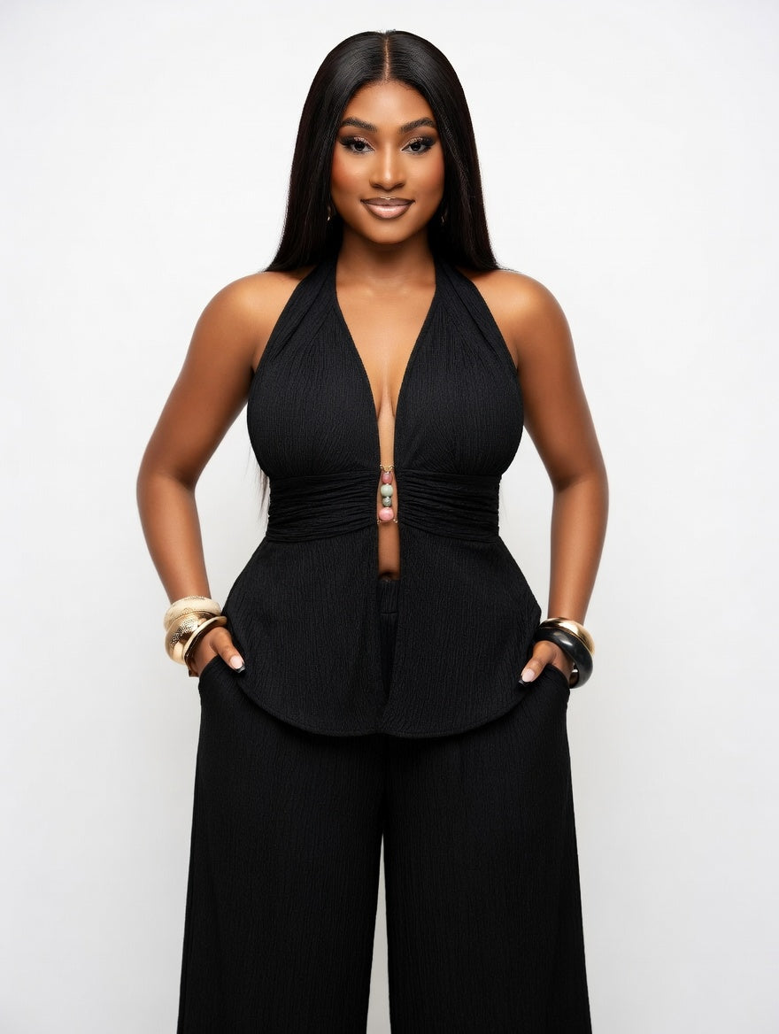 Woman wearing a black jumpsuit against a white background