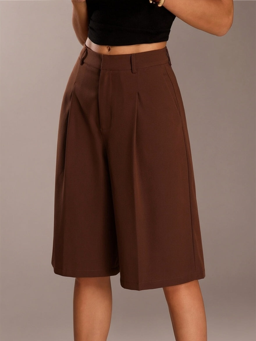 Brown pleated skirt worn by a person on a plain background