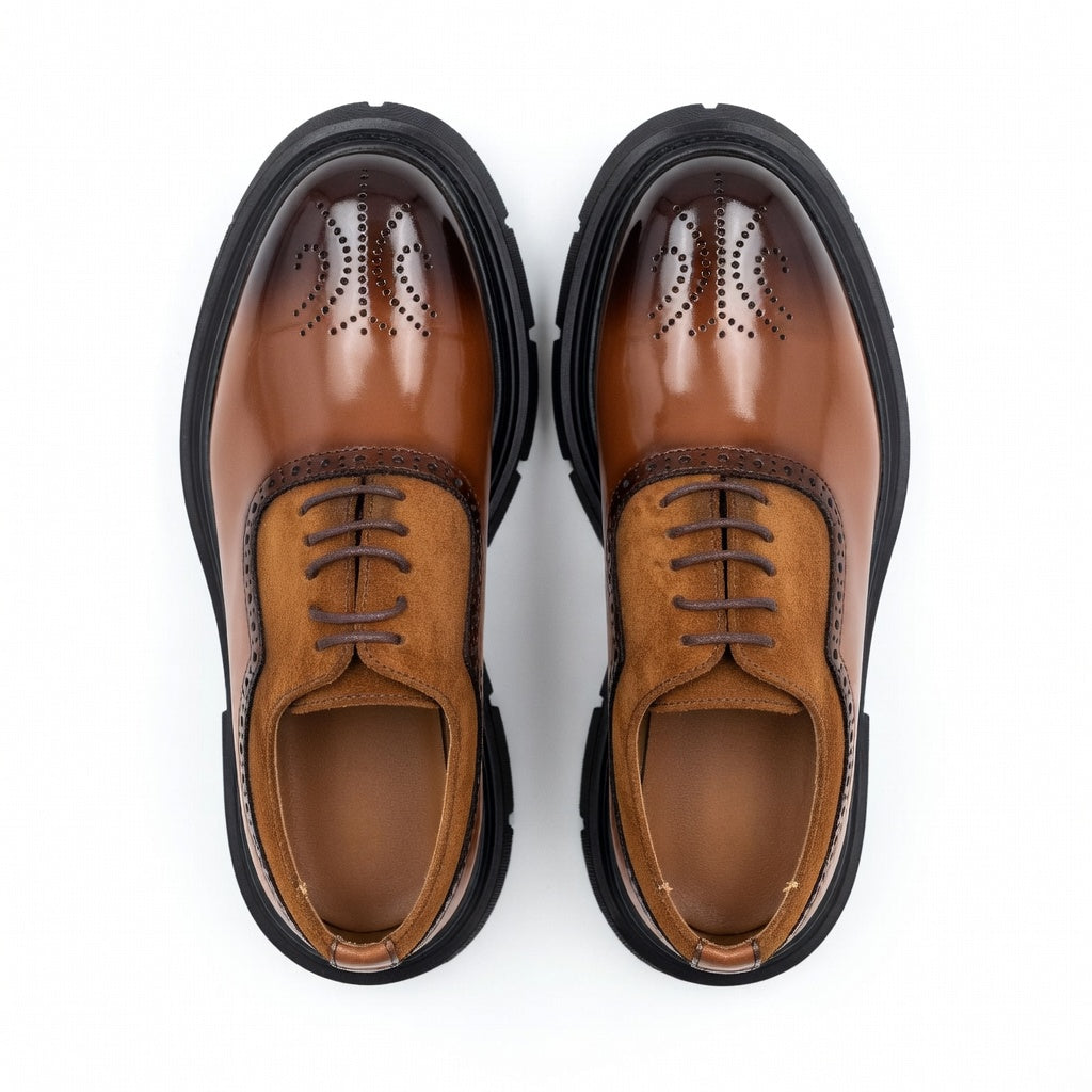 Pair of brown leather shoes with black soles on a white background