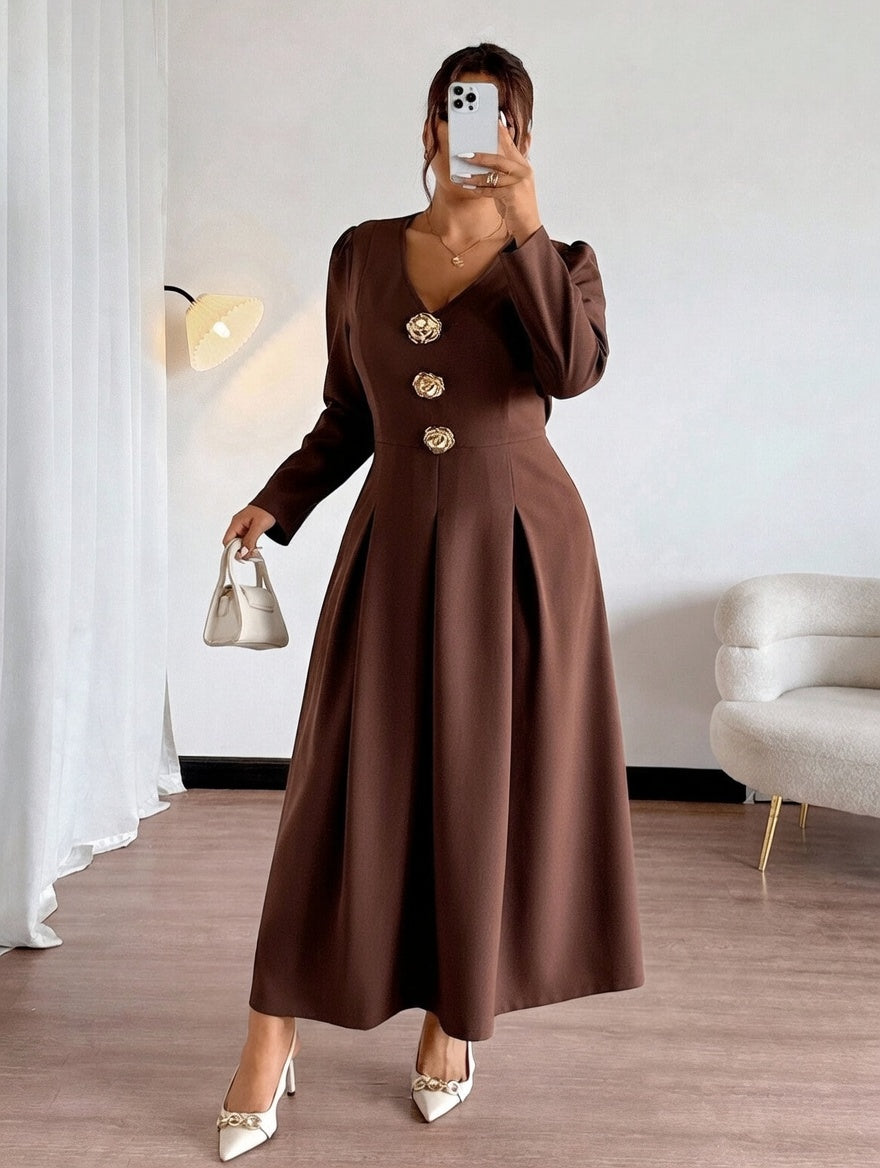 Woman wearing a brown dress with gold buttons in a room.