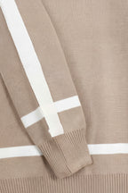 Close-up of a beige sweater with white stripes on the sleeves and neckline.