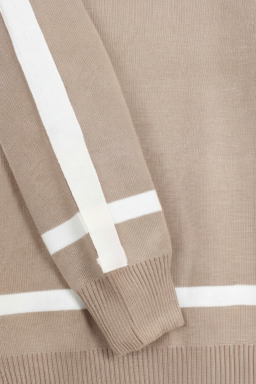 Close-up of a beige sweater with white stripes on the sleeves and neckline.