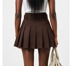 Brown pleated skirt worn by a person on a white background
