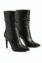 Pair of black high-heeled boots on a white background