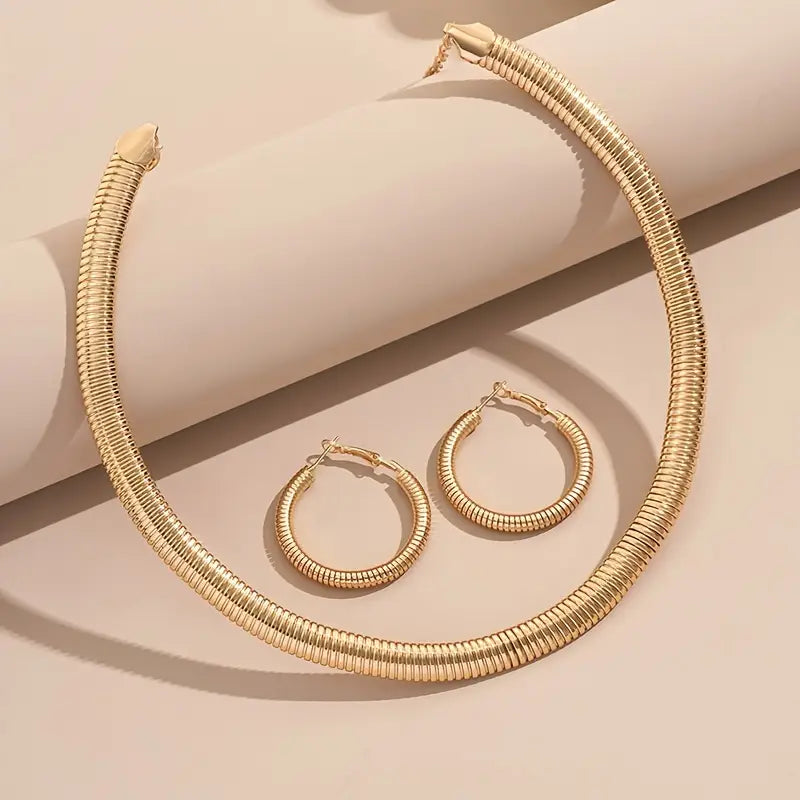 Gold necklace and hoop earrings on a beige background