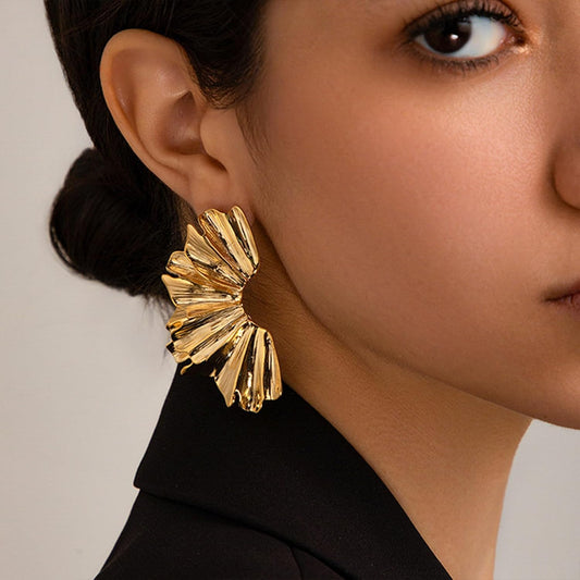 FAVEN Gold earrings worn by a person with a neutral background