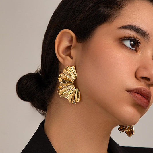 FAVEN Gold earrings worn by a person with a neutral background