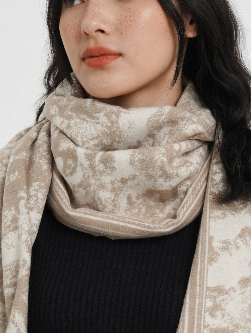 Woman wearing a beige patterned scarf on a white background