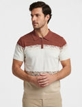 Man wearing a patterned polo shirt with a neutral background