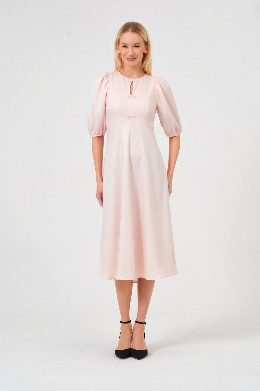 Woman wearing a light pink dress on a white background