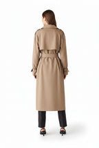 Woman wearing a beige trench coat on a white background