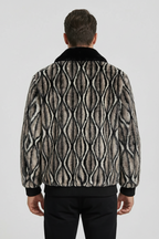 Man wearing a patterned jacket on a plain background