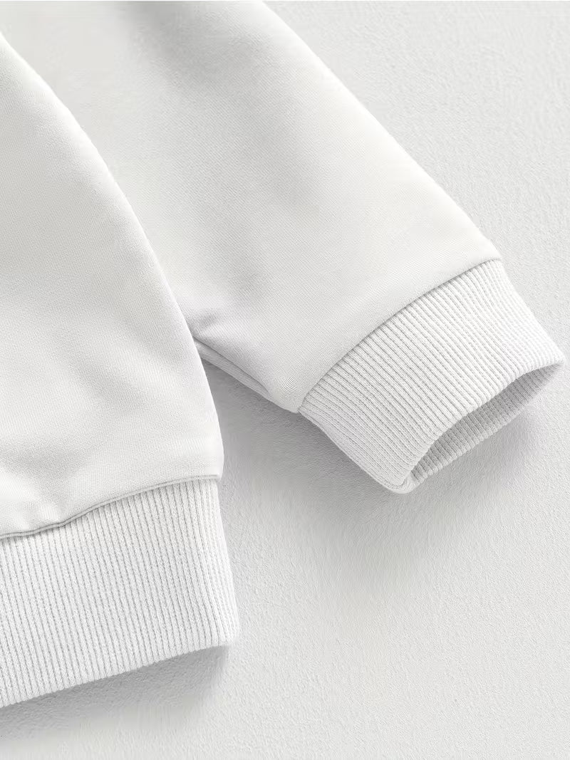 Close-up of a white sweatshirt on a light gray background