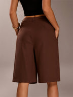 Brown shorts worn by a person on a plain background