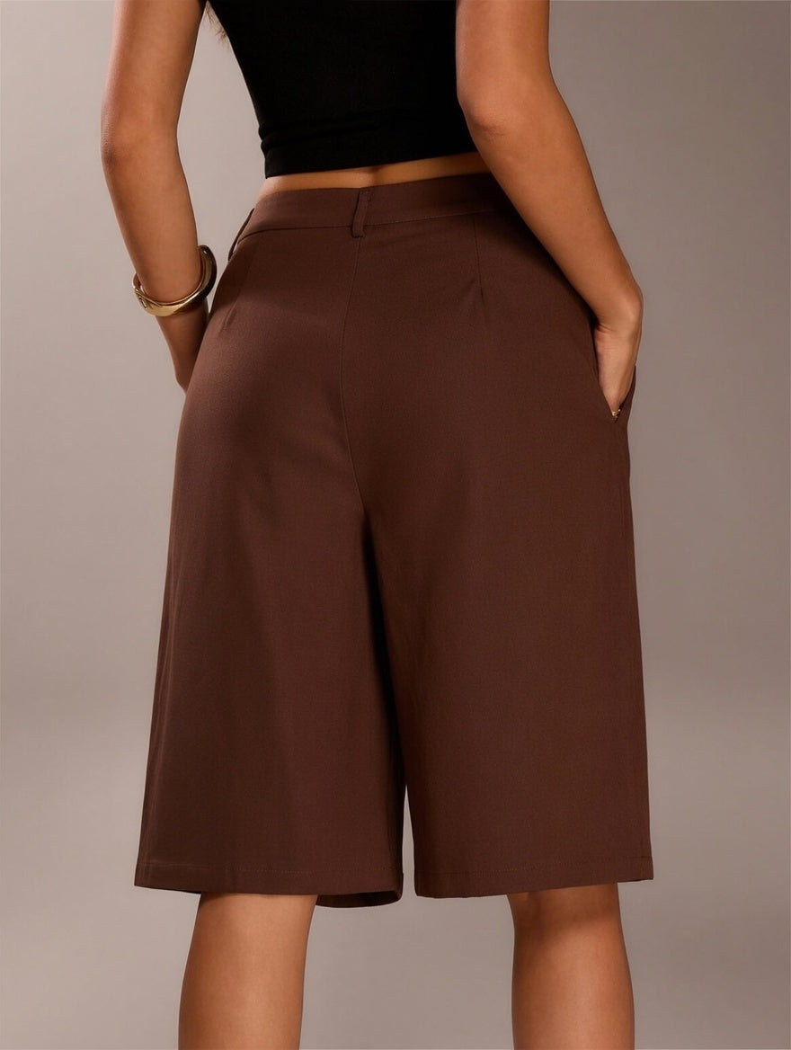 Brown shorts worn by a person on a plain background