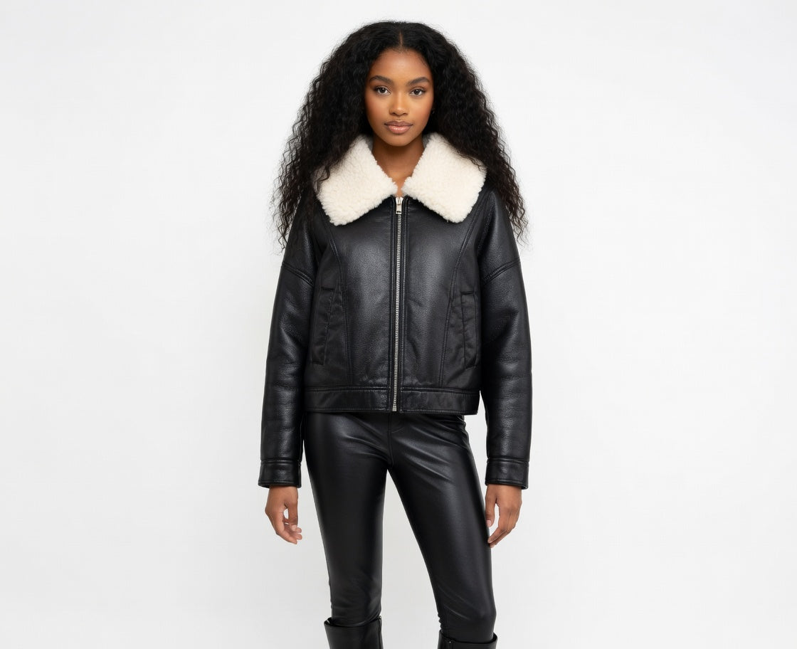 Woman wearing a black leather jacket with a white fur collar on a white background