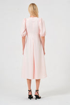 Woman wearing a light pink dress on a white background